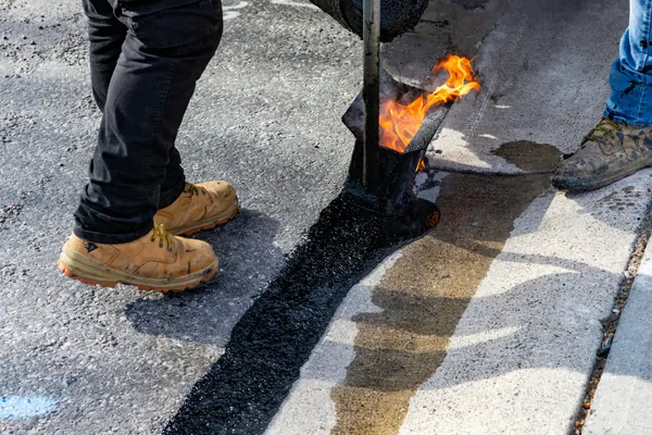 Sealed crack repair line running across an asphalt surface